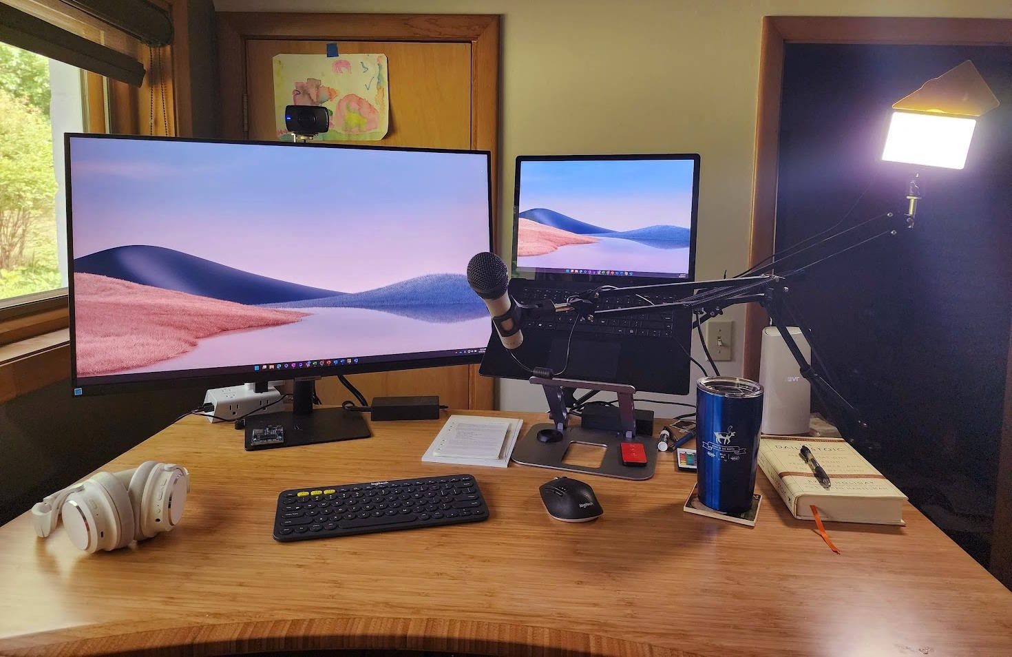 the desk setup with two cameras, two monitors, and an extra light
